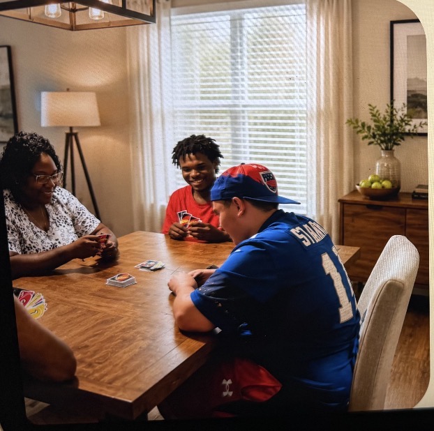 A group sharing a card game around a dining table at home